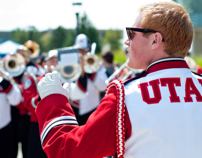 the marching band performing, with the back of the leader in focus